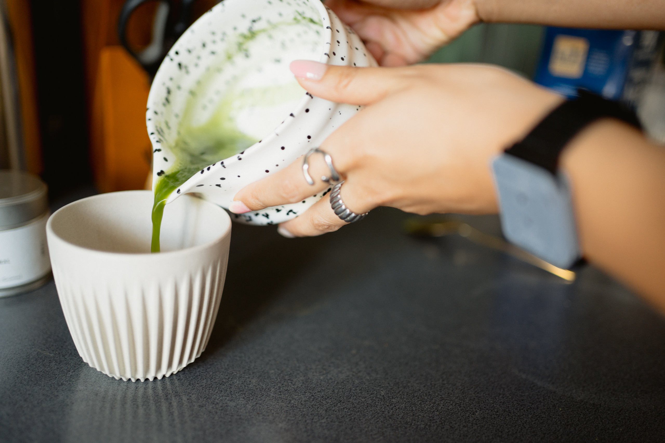 A woman preparing matcha in the kitchen, wearing tacet