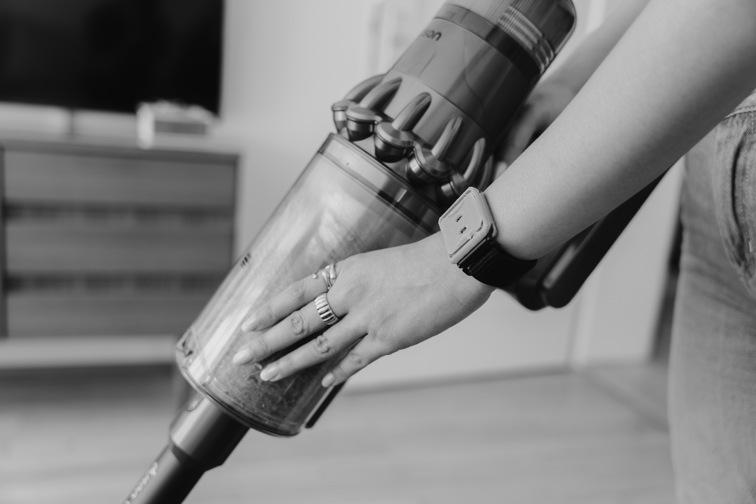 Close-up of a hand vacuuming a rug, wearing tacet